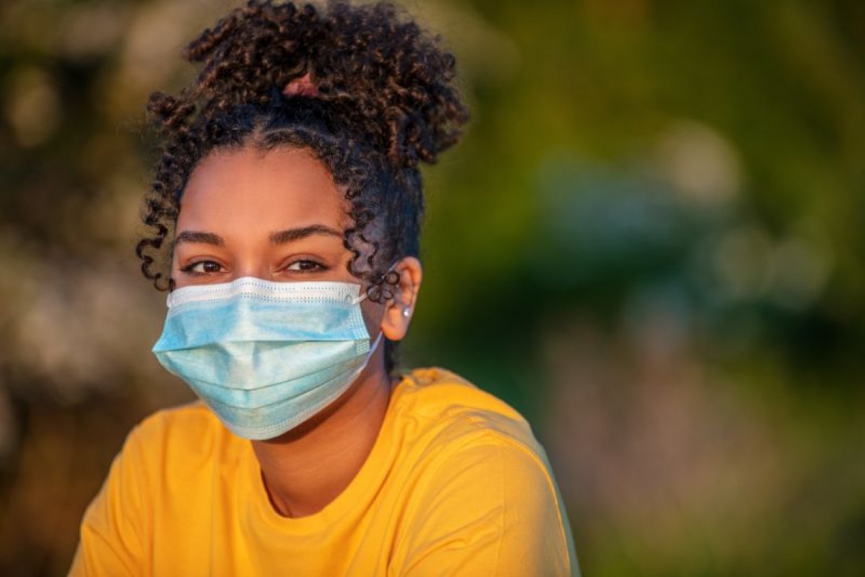 Young African-American girl wearing face mask outside